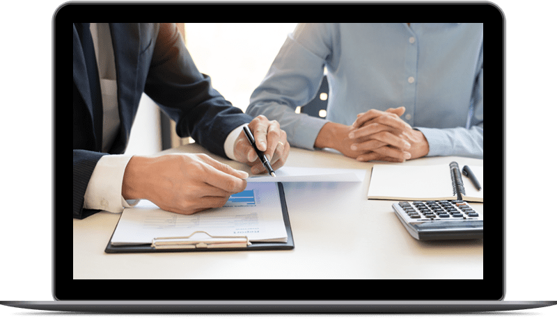 Two people are sitting at a table with papers and pens.