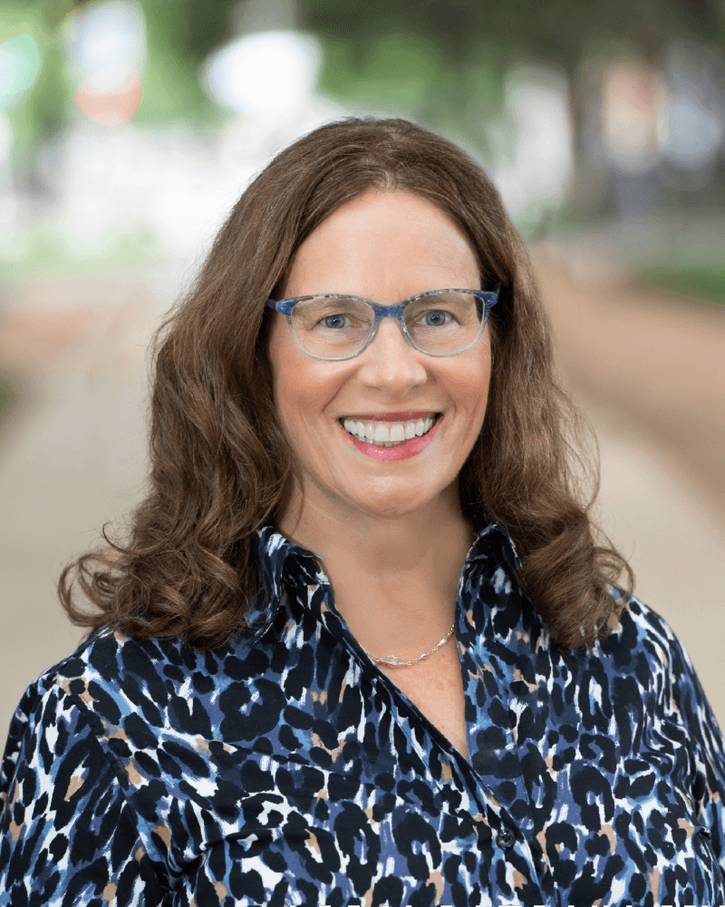 A woman with glasses and long hair wearing blue