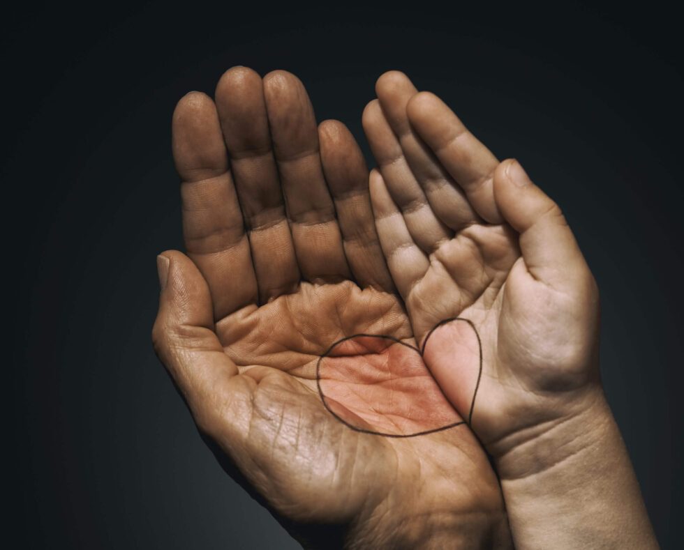 A person 's hands with their fingers crossed.