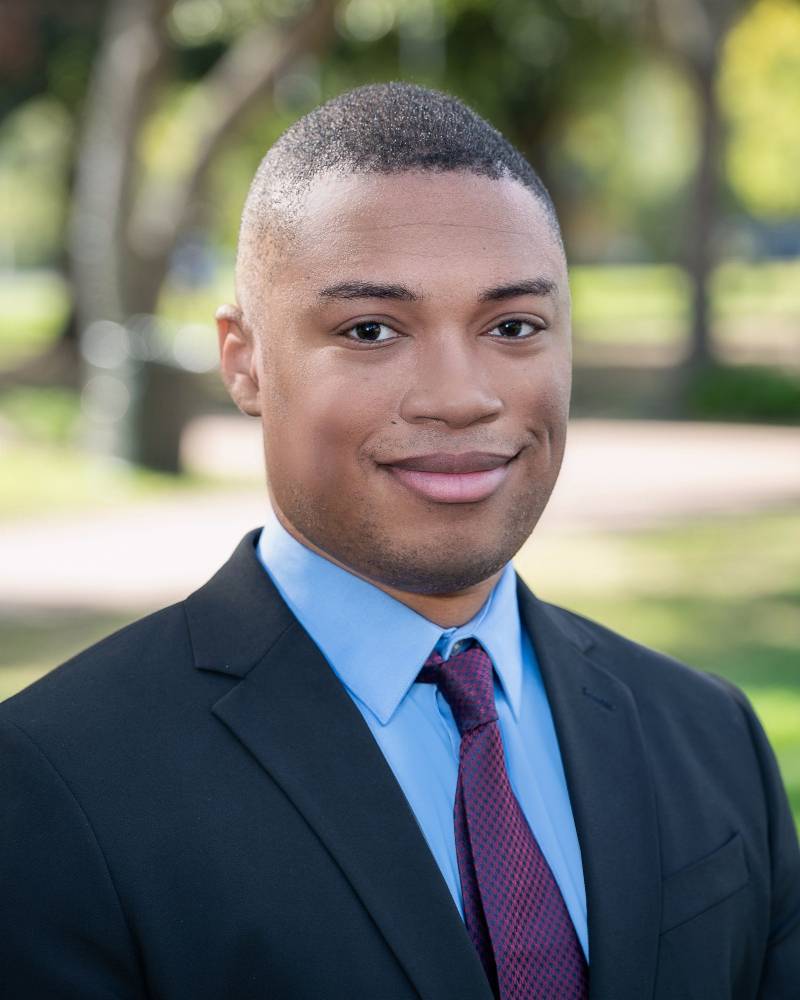 A man in a suit and tie standing outside.