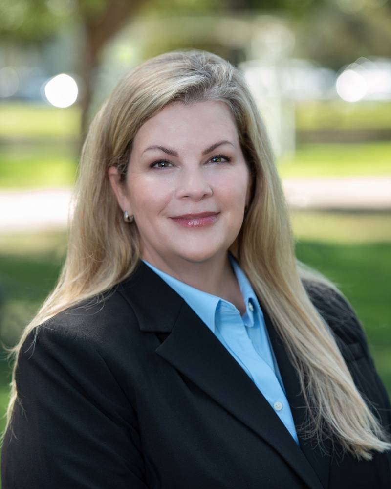 A woman in a suit and blue shirt