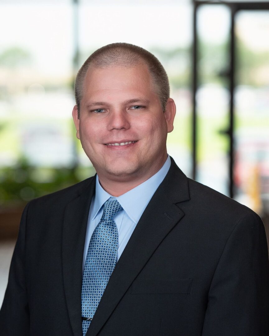 A man in suit and tie smiling for the camera.