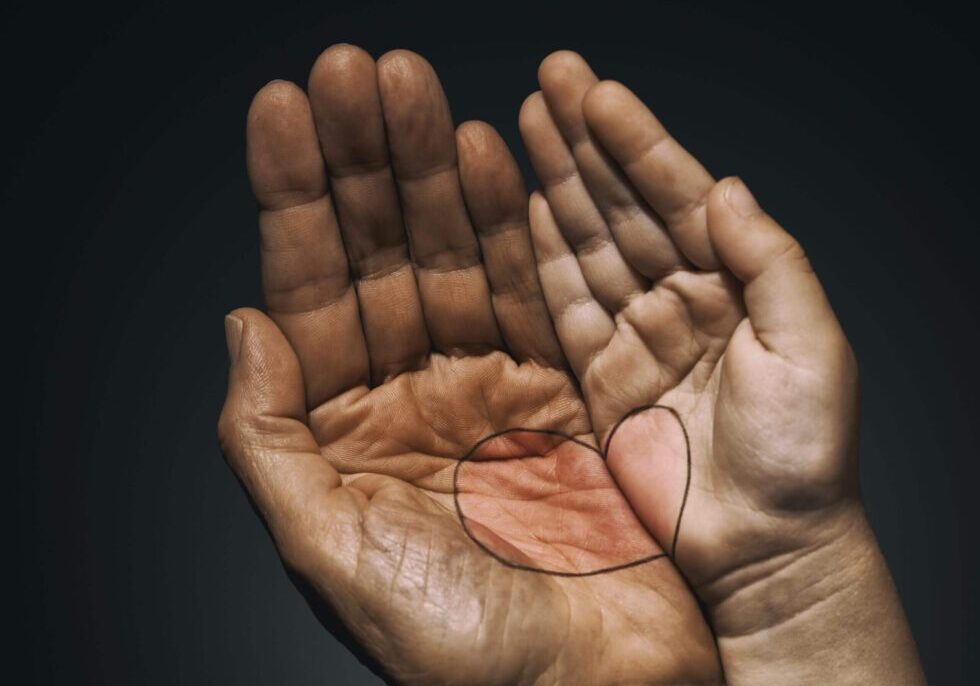 A person 's hands with their fingers crossed.